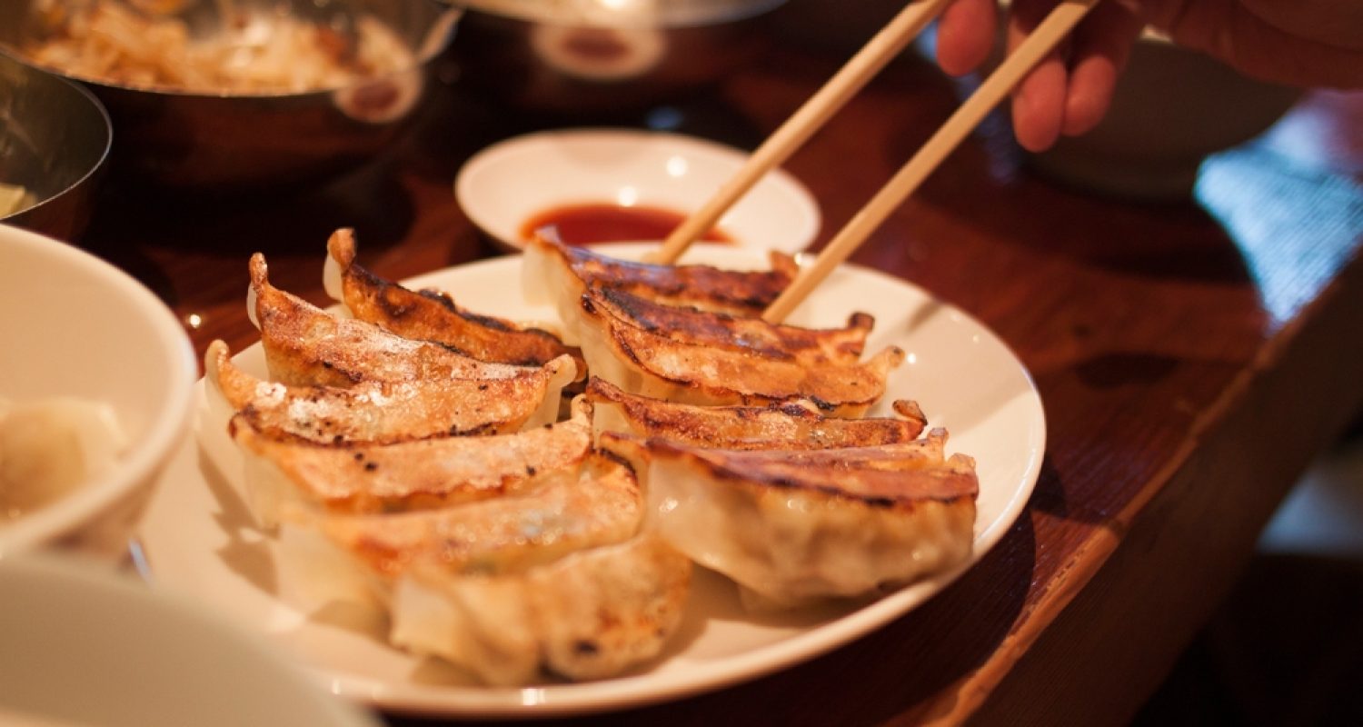 Crispy,Pan-fried,Japanese,Gyoza,Dumplings,On,A,Brown,Table,,With
